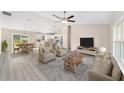 Spacious living room showcasing an open floor plan with modern furniture, light wood floors, and large windows at 20764 Sw Starling Dr, Dunnellon, FL 34431