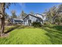 Inviting home with a lush green lawn, a grey exterior, white trim, and a detached garage at 25 Lake Wood Cir, Ocala, FL 34482