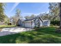 Home featuring an attached garage and a well-manicured lawn, providing convenient parking and curb appeal at 25 Lake Wood Cir, Ocala, FL 34482