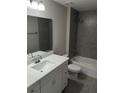 Stylish bathroom boasts a gray-tiled shower over the tub and a modern vanity at 27 Laurel Ct, Ocala, FL 34472