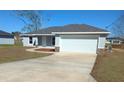 Beautiful single-story home featuring a spacious driveway and stone accent columns at 27 Laurel Ct, Ocala, FL 34472