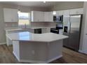 Modern kitchen features stainless steel appliances, white cabinets, and a center island at 27 Laurel Ct, Ocala, FL 34472