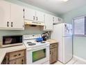 Bright kitchen featuring white appliances and upper cabinets with lower rustic wood accents at 3650 Ne 21St St, Ocala, FL 34470