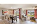 Inviting living and dining space showcasing stylish décor, neutral tones, and serene pond view through large windows at 4770 Sw 88Th Ln, Ocala, FL 34476