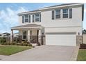 Charming two-story home featuring a manicured lawn, stone accents, and a two car garage at 5021 Sw 88Th St, Ocala, FL 34476