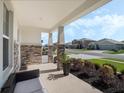 Inviting front porch with stone pillars and decorative landscaping, perfect for relaxing outdoors at 5021 Sw 88Th St, Ocala, FL 34476