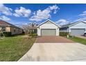 Lovely home featuring a brick driveway, attached two-car garage, and a well-maintained lawn at 5563 Nw 40Th Pl, Ocala, FL 34482