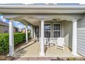 Inviting front porch featuring classic white columns and comfortable seating under a covered ceiling at 5563 Nw 40Th Pl, Ocala, FL 34482