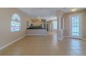 Open-concept living room with tile flooring leading to the kitchen and pool area at 5916 Nw 27Th Pl, Ocala, FL 34482