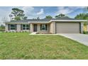 Attractive single-story home with green grass, and an attached garage at 6047 Sw 128Th Street Rd, Ocala, FL 34473