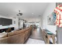 Open-concept living space with hardwood floors, modern lighting, flowing through the kitchen and dining area at 6125 Se 11Th St, Ocala, FL 34472