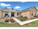 Close up of the inviting home with a brick facade, rocking chairs, and a well-manicured lawn at 7432 Ne 26Th Ave, Ocala, FL 34479