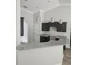 Kitchen with granite countertops, modern lighting, and dark wood cabinets against light paint at 7677 Sw 81St Pl, Ocala, FL 34476