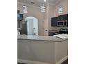 Kitchen island with granite countertop, stainless steel appliances, and sleek dark cabinetry at 7677 Sw 81St Pl, Ocala, FL 34476