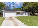 Charming single-story home featuring an attached garage, driveway, and well-manicured front lawn at 9607 Se 122Nd Pl, Belleview, FL 34420