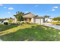 Cozy home with a green lawn, complemented by a welcoming front porch and convenient two-car garage at 1004 Parker Pl, Lady Lake, FL 32159