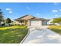 Inviting one-story home featuring a neat front yard, covered porch, and a spacious driveway at 1004 Parker Pl, Lady Lake, FL 32159