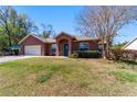 Charming single-story home with a stucco exterior, arched entry, and well-maintained lawn on a sunny day at 16272 Se 89Th Ct, Summerfield, FL 34491