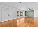 Bright living room with hardwood floors, a ceiling fan, and a large window at 1818 Se Lake Weir Ave, Ocala, FL 34471