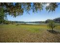 Picturesque backyard with lush greenery leading to a serene lake at 221 Se 167Th Ct, Silver Springs, FL 34488