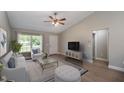 Bright and airy living room with vaulted ceilings, stylish furniture, and a large window at 29 Fisher Ter, Ocklawaha, FL 32179