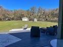 Inviting outdoor patio overlooking a large, fenced backyard with outbuildings at 5124 Cr 634S, Bushnell, FL 33513