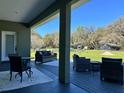 Relaxing covered patio with outdoor seating and a view of the spacious backyard at 5124 Cr 634S, Bushnell, FL 33513