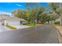 Street view featuring a charming single-story home with an attached garage and tree-lined street at 8710 Sw 91St Pl # E, Ocala, FL 34481