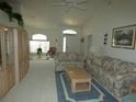 Bright living room with vaulted ceiling, carpet floors, and a large window for plenty of natural light at 9610 Sw 198Th Cir, Dunnellon, FL 34432