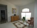Cozy sitting room with comfortable chair, decorative rug, and dresser near a window at 9610 Sw 198Th Cir, Dunnellon, FL 34432
