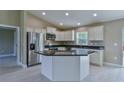 Modern kitchen with stainless steel appliances, white cabinets, and a granite island at 12805 Sw 38Th Cir, Ocala, FL 34473