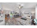 Spacious living room featuring a vaulted ceiling, stylish furniture, and seamless flow to the kitchen at 13105 Sw 77Th Ct, Ocala, FL 34473