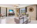 Bright living room with neutral tones features contemporary decor, a ceiling fan, and tile flooring at 2163 Ne 28Th Ln, Ocala, FL 34470