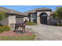 Elegant home exterior featuring stone accents, arched entrance, and manicured landscaping with a horse statue at 4695 Ne 112Th Ln, Anthony, FL 32617