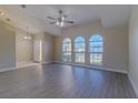 Vaulted living room with luxury vinyl plank flooring, ceiling fan, and arched windows providing ample natural light at 5115 Nw 21St Loop, Ocala, FL 34482
