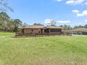 The backyard features a spacious lawn, a wooden fence, and an enclosed porch at 5401 Sw 140Th Ave, Ocala, FL 34481