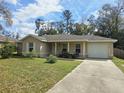 Inviting one-story home featuring an attached garage and a well-kept lawn at 5520 Nw 57Th St, Ocala, FL 34482