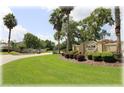 Deer Path Estates entrance sign surrounded by lush landscaping, mature trees, and colorful flower beds at 6307 Se 8Th Ln, Ocala, FL 34472