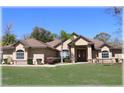 Inviting single-story home with a lush green lawn, mature trees, and a double-door entry, complete with manicured landscaping at 6307 Se 8Th Ln, Ocala, FL 34472