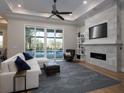 Bright living room with modern fireplace, large windows, and hardwood floors at 7635 Nw 33Rd Pl, Ocala, FL 34482