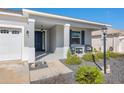 Welcoming front porch with seating, a manicured front yard, and a stylish entry door at 7698 Sw 85Th Cir, Ocala, FL 34481