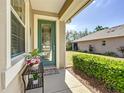 This cozy front porch has decorative door, flowers, and green plants surrounding it at 9346 Sw 73Rd St, Ocala, FL 34481