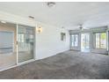 Enclosed sunroom features carpet floors, ceiling fan, large windows offering views of the outside, and sliding door access at 9886 Se 178Th Ln, Summerfield, FL 34491