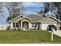 Charming single-story home with a well-manicured lawn, neutral exterior, and attached two-car garage at 1645 Sw 168Th Loop, Ocala, FL 34473