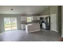 Modern kitchen featuring white cabinets, stainless steel appliances, and an island, perfect for cooking at 17672 Sw 112Th Ln, Dunnellon, FL 34432