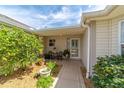Inviting front porch with charming potted plants and seating, creating a cozy entrance at 17959 Se 89Th Natchez Ave, The Villages, FL 32162