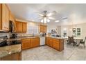 Spacious kitchen featuring oak cabinets, granite countertops, stainless steel appliances, and an adjacent dining area at 17959 Se 89Th Natchez Ave, The Villages, FL 32162