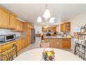 Spacious kitchen featuring wooden cabinetry, tile backsplash, granite counters and stainless steel appliances at 17959 Se 89Th Natchez Ave, The Villages, FL 32162