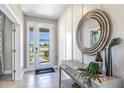 Inviting foyer showcasing a decorative mirror, console table, and light tile flooring for a bright entrance at 4250 Sw 53Rd Lane Rd, Ocala, FL 34474