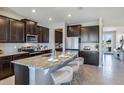 Stylish kitchen featuring dark cabinetry, granite countertops, a central island with seating, and stainless appliances at 4250 Sw 53Rd Lane Rd, Ocala, FL 34474